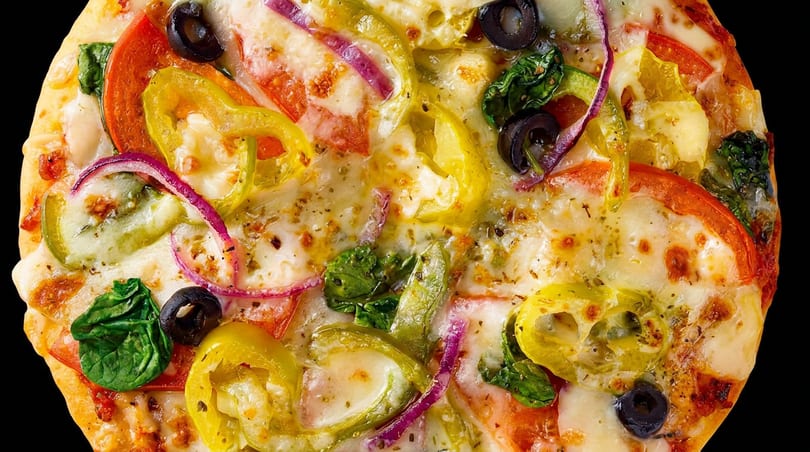 Delicious pizza topped with melted cheese, fresh tomatoes, peppers, red onions, olives, and spinach.