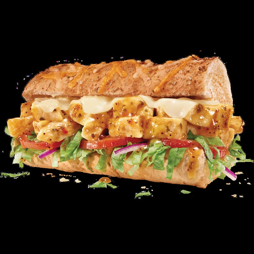 A long submarine sandwich with sauced chicken, melted cheese, fresh lettuce, tomatoes, and red onions.